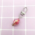 Close-up of pink metallic jellyfish keychain with silver lobster clasp on grid background - Jellyfish/Iridescent Pink