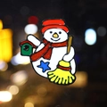 Broche bonhomme de neige de Noël avec écharpe pailletée sur fond d'ambiance festive - Bonhomme de Neige avec Balai