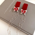 Dettaglio di fermagli per capelli a farfalla floccati rossi con strass e lunghe nappe - Fermaglio per Capelli con Farfalla e Nappa (Singolo) / Rosso