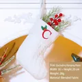 White knitted Christmas stocking with red letter C embroidery on a cozy mantel decoration - Letter C
