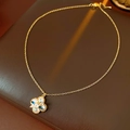 Gros plan d'un collier pendentif fleur avec zircon et perles sur cuir marron - Style Floral Bleu / Doré