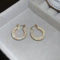 Detail von vergoldeten U-förmigen Ohrringen mit Zirkonia-Besatz auf grauem Samt - Groß / Gold (Echtgold Vergoldet)