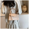 Detail of beige crocodile pattern handbag with unique knot handle and crossbody strap - Beige