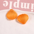 Gros plan de coquillages en résine orange en forme d'éventail avec paillettes pour bijoux - Orange