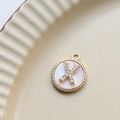 Macro detail of gold plated letter X pendant with white shell inlay and zircon stones - X Round