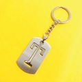 Silver stainless steel hollow letter T keychain with matte finish on yellow background - Letter T