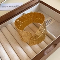Macro shot of gold wide hinged cuff bracelet with leaf texture in a jewelry box - Gold Leaf Vein Embossed Texture Style