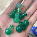Handheld view of seven 2cm mini green agate mushroom figurines for garden decor - Green Agate