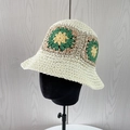 Detailed close-up of handmade crochet bucket hat with colorful flower patterns - Creamy White