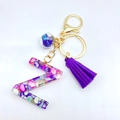 Letter Z resin keychain with purple tassels and seashell inlay on white background - Letter Z