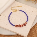 Detail of blue seed beads and red natural stones with a gold adjustable clasp - Royal Blue