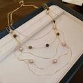 Dettaglio della collana multistrato con occhio di tigre e perle su vassoio per gioielli - Collana-Oro-Occhio di Tigre