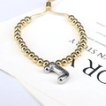 Detail of adjustable gold beaded bracelet featuring a silver balloon letter J charm - Letter J