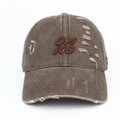 Close-up of distressed vintage wash baseball cap with OXKO embroidery and ripped details - Coffee