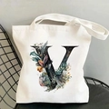 Detail of white canvas tote bag with floral letter V print on a modern black wire chair - Letter V / 35*40cm