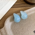 Detail view of light blue resin teardrop earrings with marble texture on vintage background - Marble Blue
