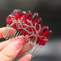 Detailaufnahme von rotem Kristall-Haarkamm mit silbernen Zweigen in der Hand gehalten - Dunkelroter Kristall + Zweig