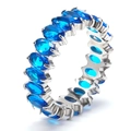 Close-up of eternity ring with oval blue stones and silver plating in claw setting - Silver + Blue Zirconia