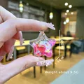 Glittering star-shaped resin pendant with pink gradient and colorful sequins in hand - No Keychain / Pink
