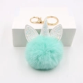 Close-up of mint green unicorn pompom keychain with glitter horn and golden clasp - Unicorn Gold Keychain / Mint Green