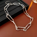 Primer plano de un collar de cadena gruesa de plata con textura martillada sobre base negra - Plateado