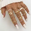 Detailopname van een hand met een 9-delige gouden vlinder- en parelringset met witte nagels - Goud (HS1304-36)