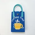 Detail of blue knitted phone bag featuring coffee time pattern and round blue handle - Coffee Deep Blue