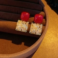 Macro-opname van rode vierkante oorknopjes met zirkoon op bruin fluwelen displaydoos - Rood Vierkant Zirkoon Stijl / Rood goud