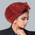 Metallic red pleated turban hat with a large glitter bow shown on a female model - Burgundy