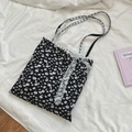 Detailweergave van gebloemde canvas tas met delicate witte kanten randen en riemen - Zwart
