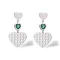 Gros plan de boucles d'oreilles cœur en argent avec pierre verte et détails filigranes - Argenté