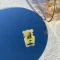 Pince à cheveux ours jaune translucide avec lettrage doré sur fond de ciel bleu clair - Ours Jaune Gelée