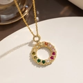 Elegant gold titanium necklace with a colorful zircon donut pendant on a white pedestal - Colorful Rhinestone Donut (301)