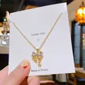 Collier élégant en acier titane doré avec pendentif nœud en cristal sur carte de présentation - Nœud en Zirconium Or