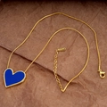 Detail of gold snake chain with a deep blue heart pendant on textured paper background - Gold Blue Necklace