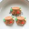 Macro detail of DIY resin tree stump miniatures with red mushrooms and green leaves - Stump