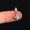 Silver piercing stud featuring a sparkling zircon butterfly pendant held on a finger - CC167-1 Silver Butterfly