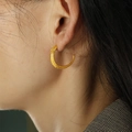 Gepolijste 18K vergulde C-vormige oorbellen met stippelpatroon op een model - Goud (EH57)