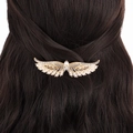 Dettaglio di un fermaglio per capelli ad ali d'angelo con strass e perle su capelli castani - Stile Ala d'Angelo