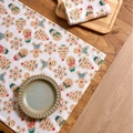 Gingerbread man printed Christmas napkins on a rustic wooden table with holiday decor - White Background Gingerbread Man