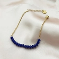 Elegant gold chain bracelet with deep blue faceted beads on soft pink silk background - Blue