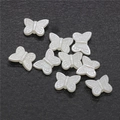 Detalle macro de cuentas de mariposa blancas para joyería DIY y accesorios para el pelo - 14mm Mariposa