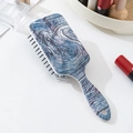 Dettaglio della spazzola per capelli con cuscinetto d'aria e motivi a vortice blu e viola - Trama Blu Bianco