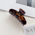 Close-up of a large tortoiseshell acetate hair claw clip with golden B-letter accent - Gold B Logo / Tortoise