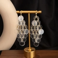 Detail of bohemian drop earrings with clear acrylic discs on gold jewelry display stand - H3533-1 Style