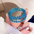 Vista dettagliata di perle in cristallo sfaccettato azzurro su bracciale a tre strati - Blu
