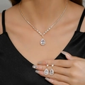 Luxurious gold zirconia necklace and teardrop earrings set on elegant female model - 2-Piece Set / Gold