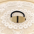 Minimalist elastic hair tie featuring a polished gold oval metal charm on black band - Gold Smooth Oval