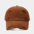 Close-up of distressed vintage baseball cap with frayed edges and ripped cotton texture - Tan