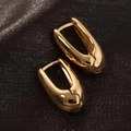 Sleek gold-plated metal teardrop huggie earrings with polished finish on black background - Small Gold Teardrop Ear Buckle
